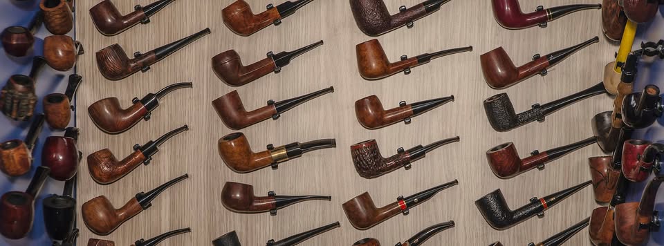 Dozens of Asikyan pipes hung in columns on a workshop board